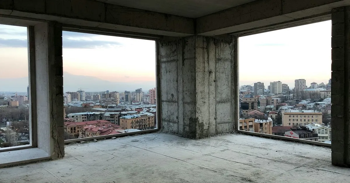 Apartamento en obra gris con placa y columnas de concreto a la vista, vanos sin ventanas y vista a la ciudad