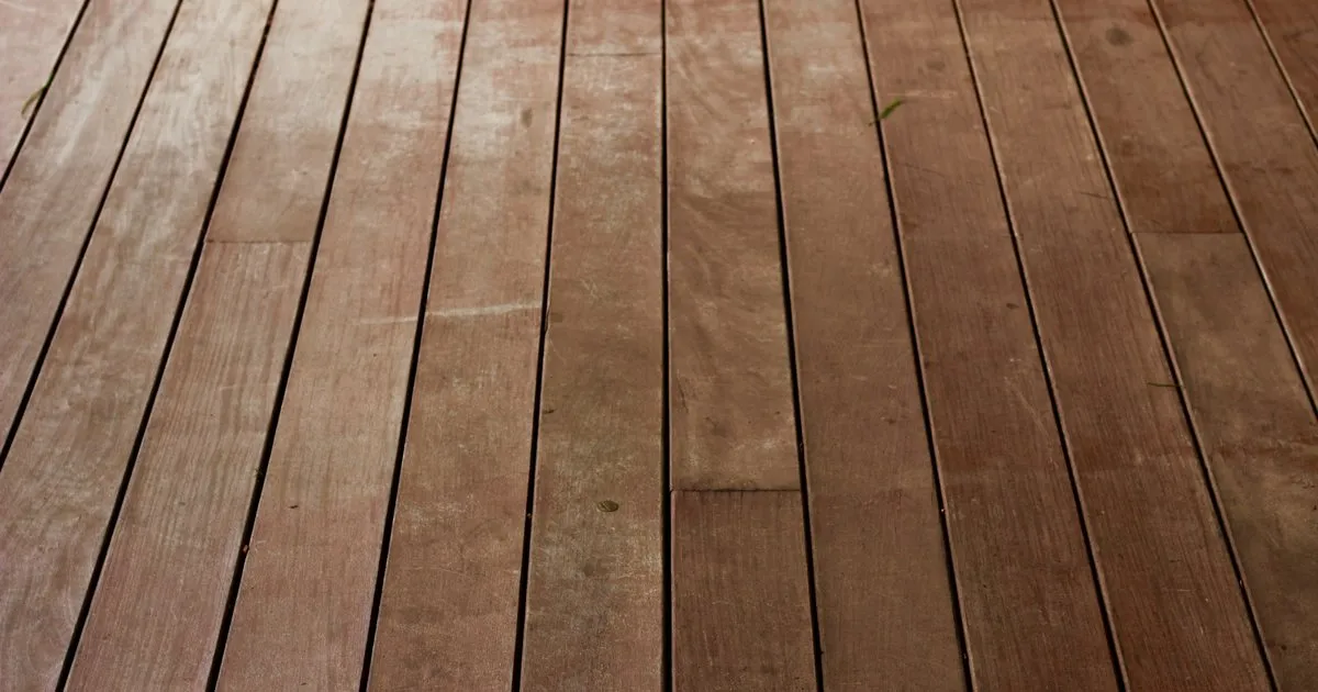 Primer plano de las tablas de un deck de madera de tono rojizo con la veta y las juntas a la vista